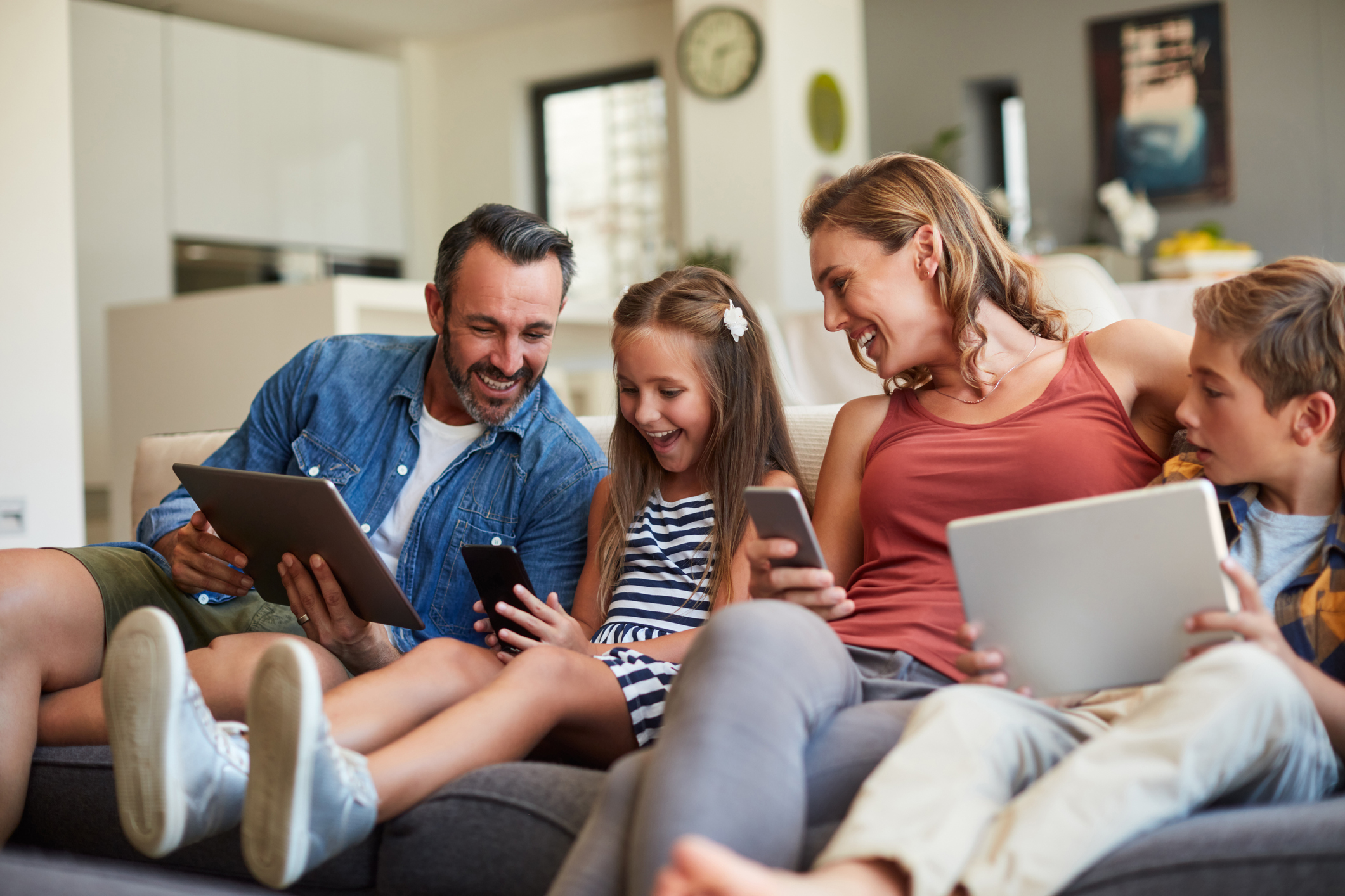 Family on couch with devices 