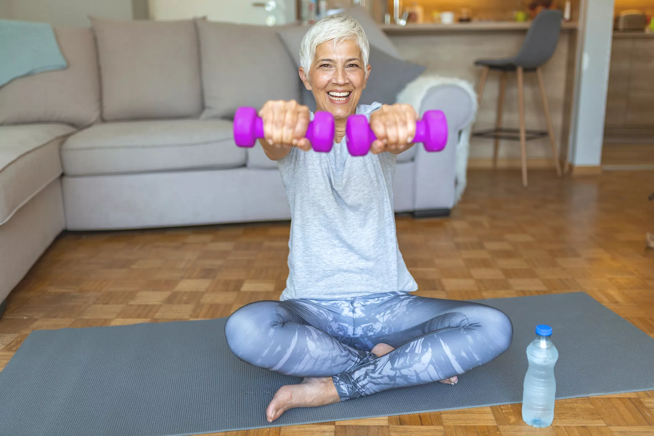 Senior with dumbells at home